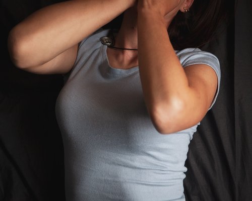 A person gently stretching their arms and neck at work