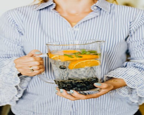 Glass pitcher filled with fresh fruit infused water